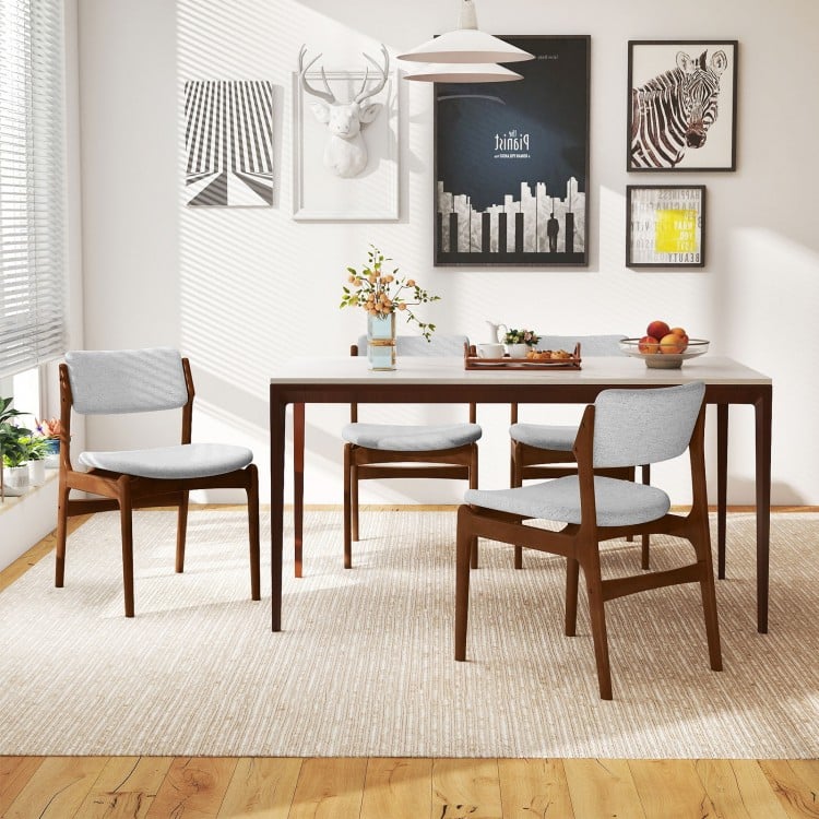 Modern padded dining chairs with rubber wood legs in brown, featuring soft cushions and a stylish farmhouse design.