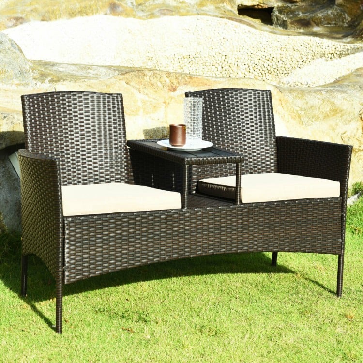 Modern patio conversation set featuring two seats with beige cushions and a trapezoid coffee table for outdoor.
