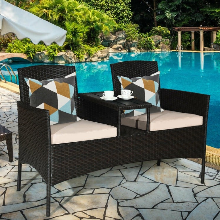 Modern patio conversation set featuring a trapezoid coffee table, beige cushions, and durable rattan for outdoor.