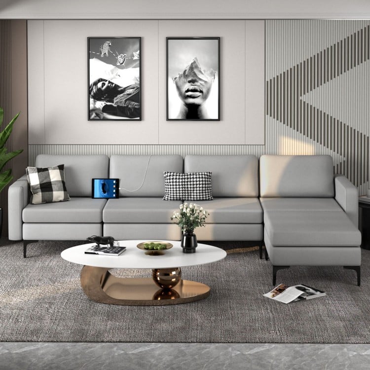 Light gray modular L-shaped sectional sofa with reversible ottoman, USB ports, and ergonomic backrests for comfort.