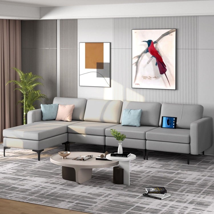 Light gray modular L-shaped sectional sofa with reversible ottoman and USB ports, perfect for modern living rooms.