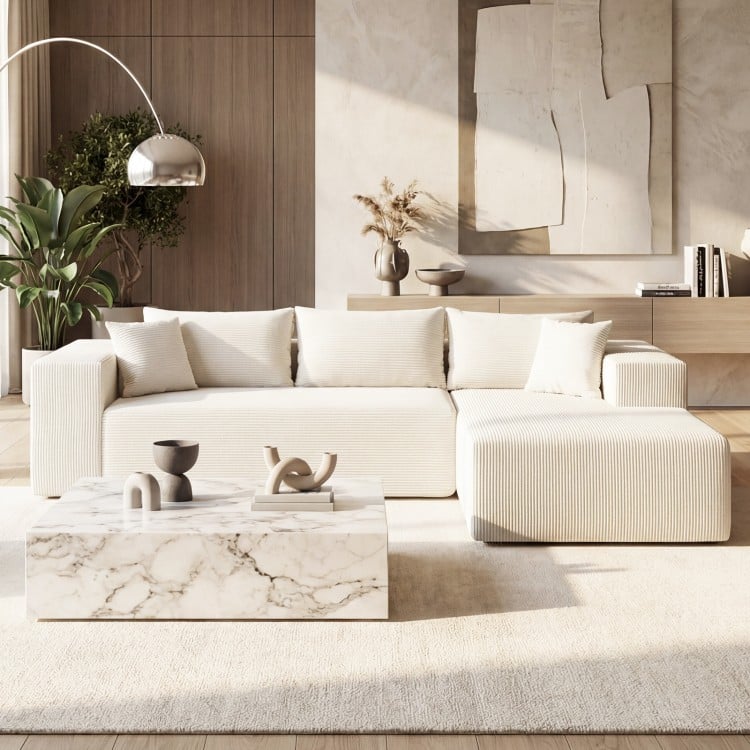 L-shaped modular sectional sofa in beige corduroy, featuring deep seats and supportive backrests for ergonomic comfort.