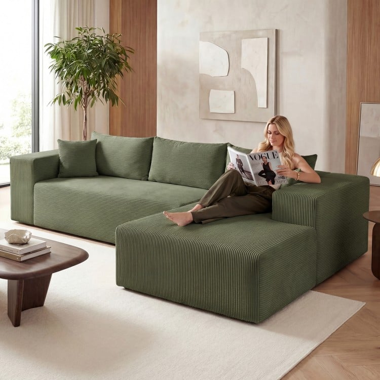 L-shaped modular sectional sofa in green corduroy, featuring deep seats and supportive backrests for ergonomic comfort.