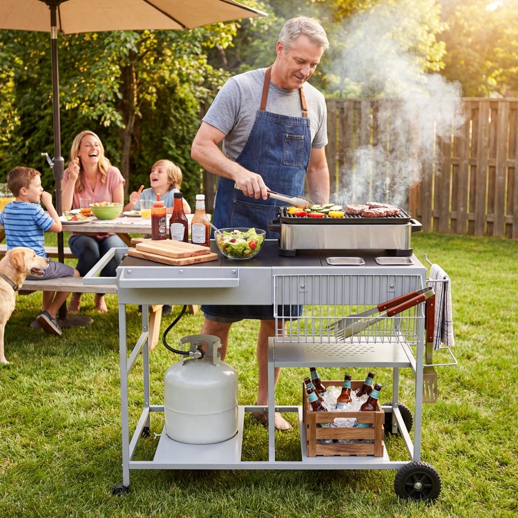 Movable grill table in black with spacious tabletop, condiment caddies, and wheels for backyard BBQs and picnics.