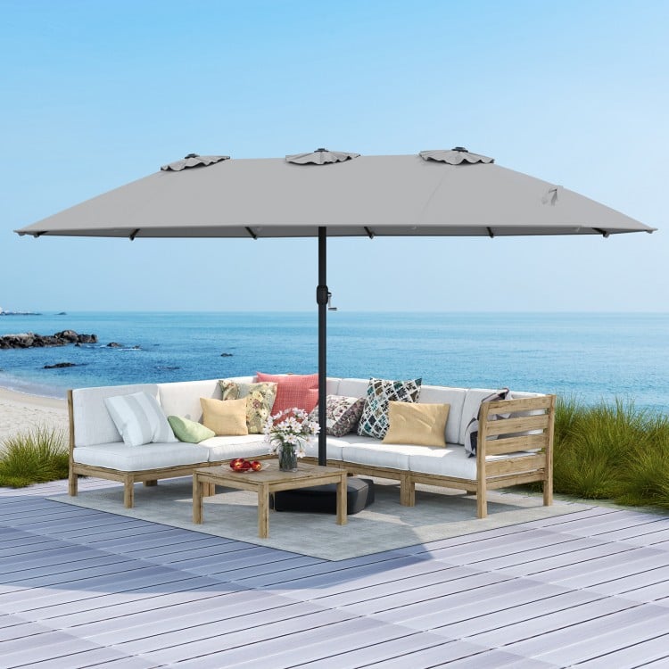 Double-sided 15ft patio umbrella in market-gray with a sturdy base, ideal for outdoor shading and relaxation.