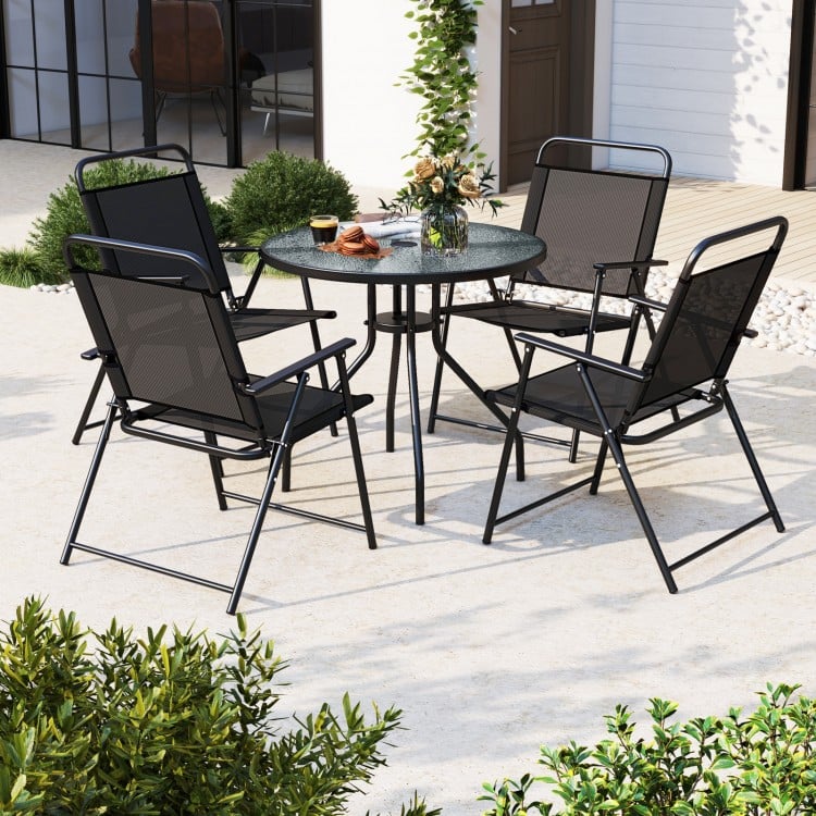 Patio dining set featuring four folding chairs and a glass table with a 71" tilt umbrella, perfect for outdoor.