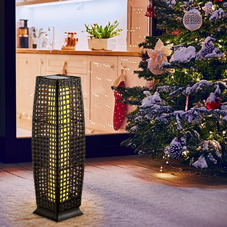 Black solar-powered wicker floor lamp with warm yellow LED light, ideal for outdoor use on patios or gardens.