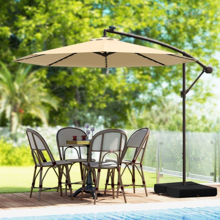 10-foot cantilever umbrella in beige with solar LED lights, supported by a sturdy base, perfect for outdoor dining.