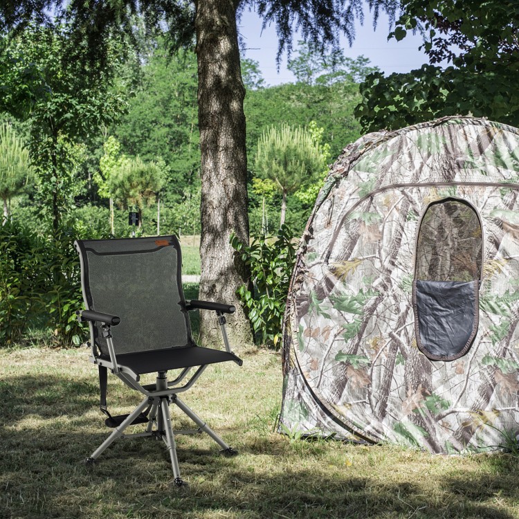 Black 360-degree silent swivel hunting chair with adjustable armrests, set up beside a camouflage tent in a natural.