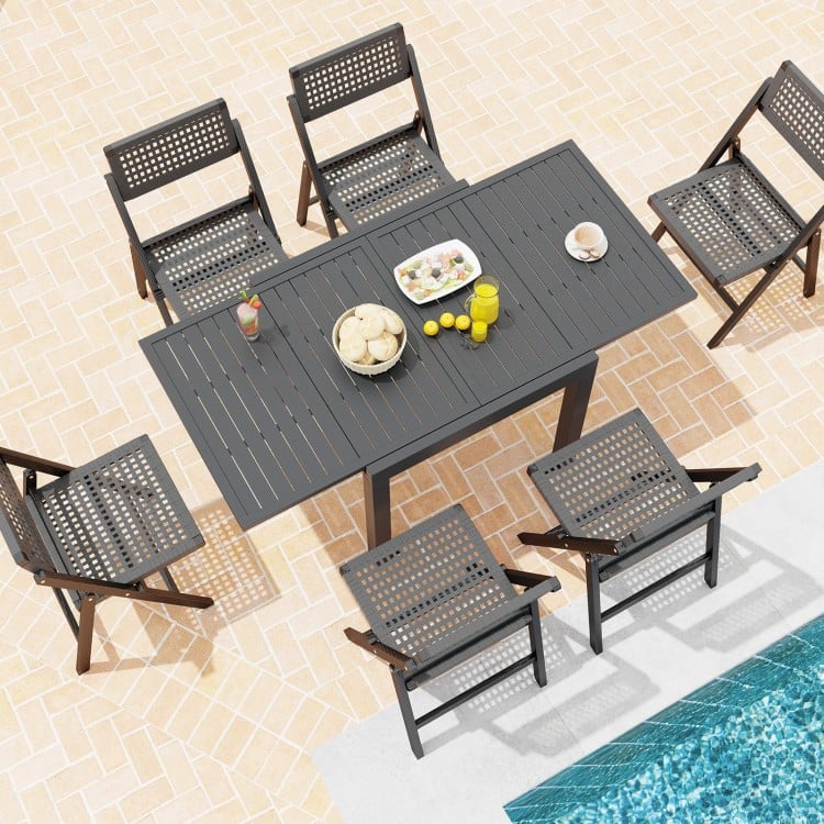 Expandable grey patio dining table for 4-6 people with slatted top, surrounded by chairs, ideal for outdoor gatherings.
