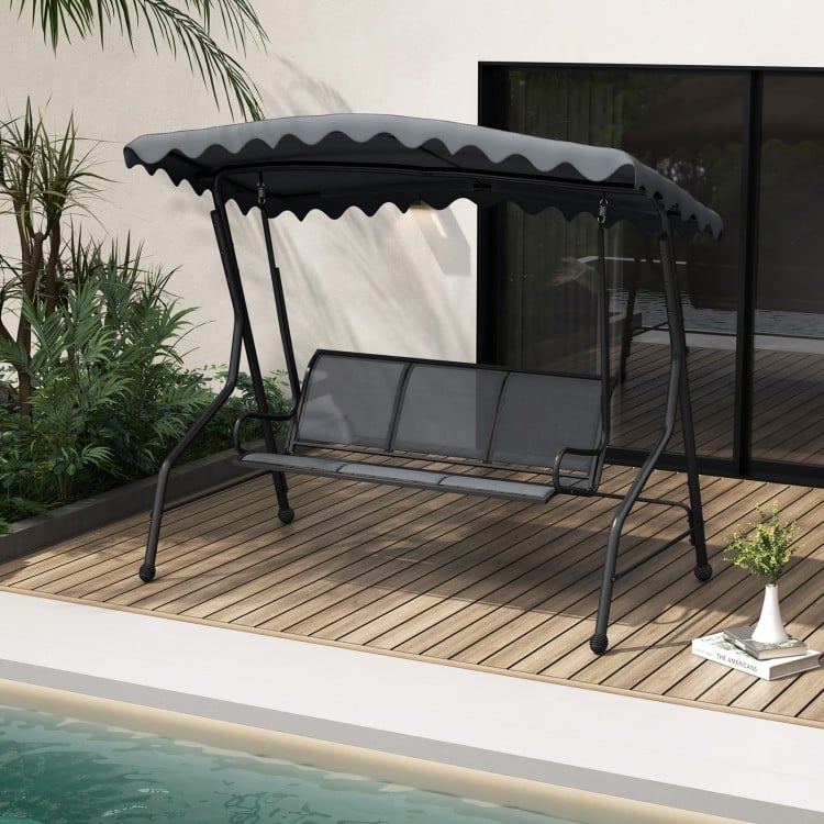 Three-seat outdoor porch canopy swing in gray with adjustable shading, perfect for backyard or poolside relaxation.