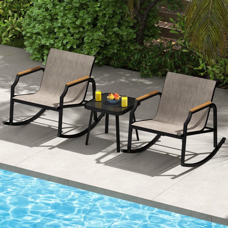 Two brown patio rocking chairs with wood-like armrests and a tempered glass coffee table by a pool for outdoor.