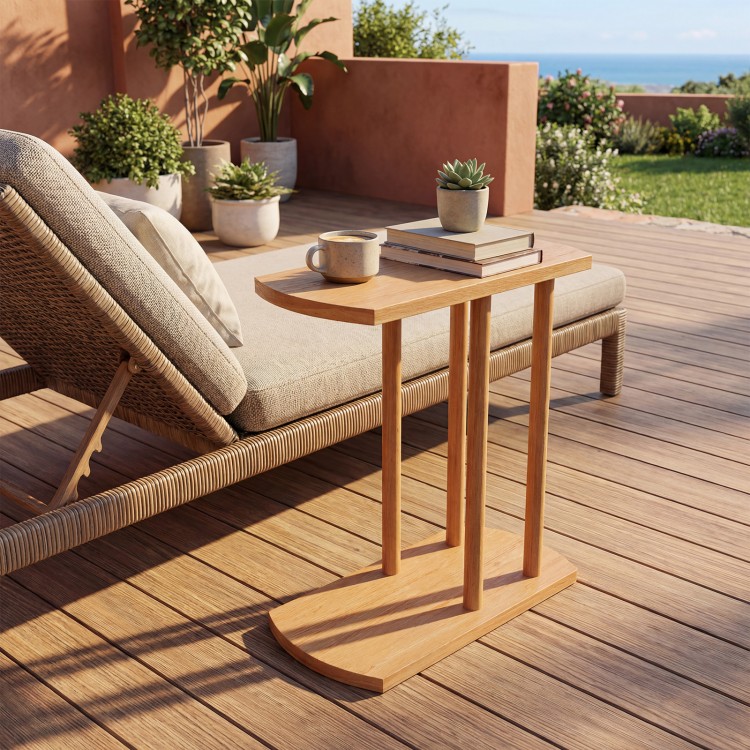 Narrow C-shaped teak wood side table with two tiers, ideal for outdoor use beside a lounge chair.