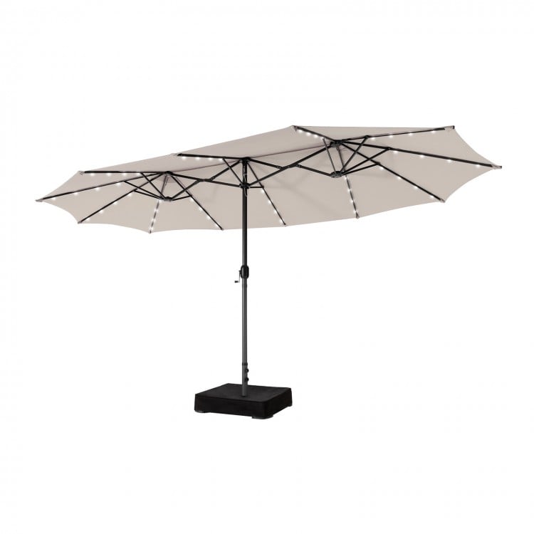 Double-sided patio umbrella with beige canopy and solar-powered LED lights, featuring a vented top for improved airflow.