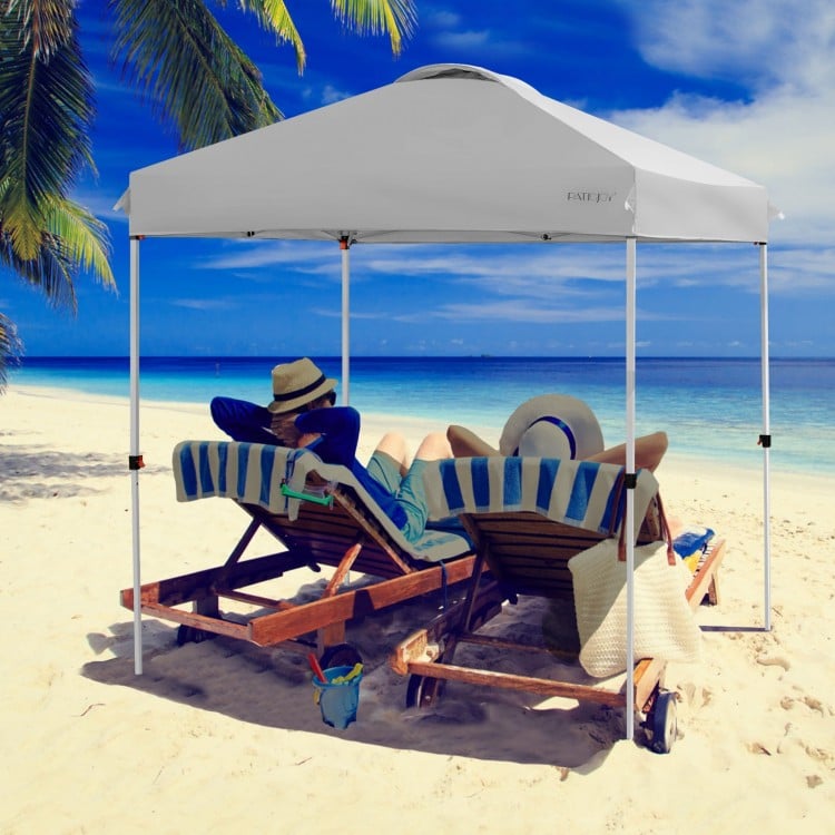 Gray 6.6 x 6.6 feet outdoor pop-up canopy tent providing shade for beach relaxation, featuring a heavy-duty steel frame.