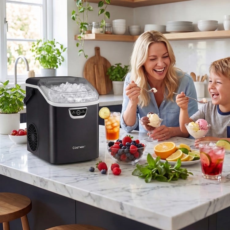 Nugget ice maker in black on a kitchen countertop, producing ice while a family enjoys ice cream together.