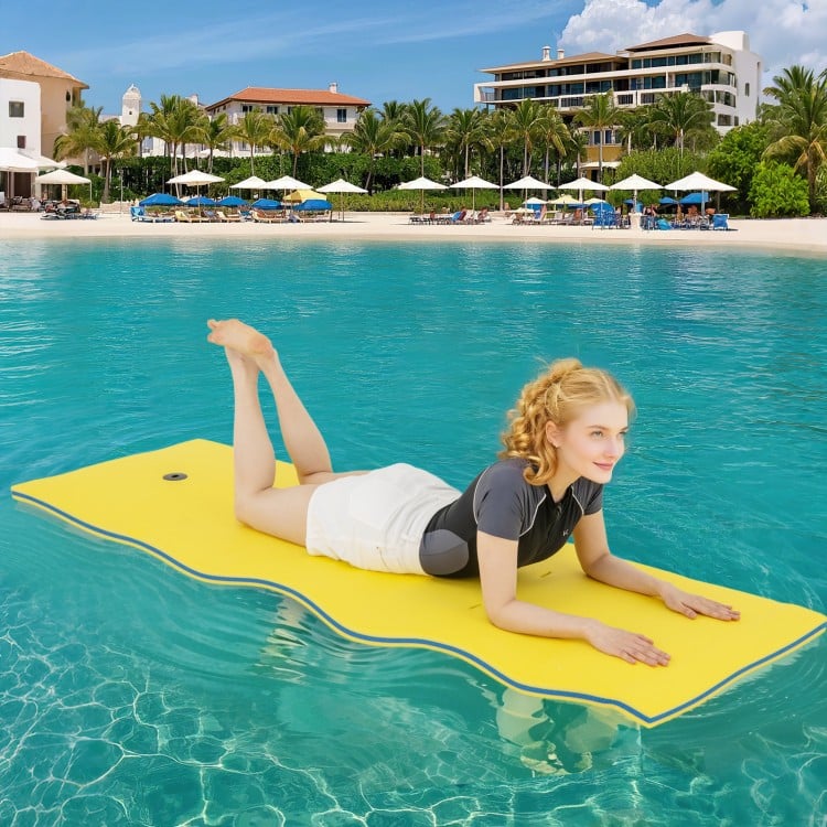 Bright yellow 3-layer foam floating pad in use on water, featuring a smooth surface for comfort and relaxation.