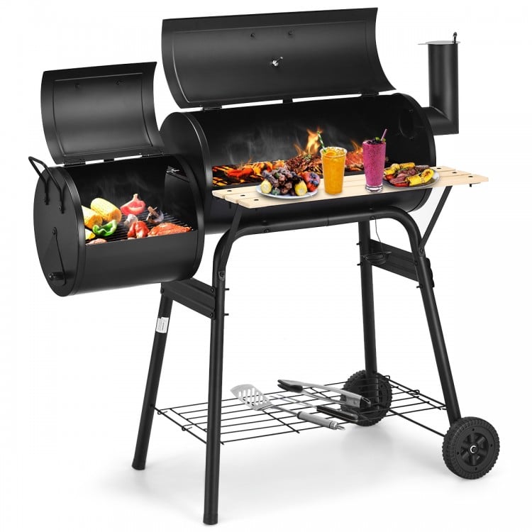 Outdoor BBQ grill with heavy-duty steel construction, side shelf for tools, and attached firebox for offset heat.