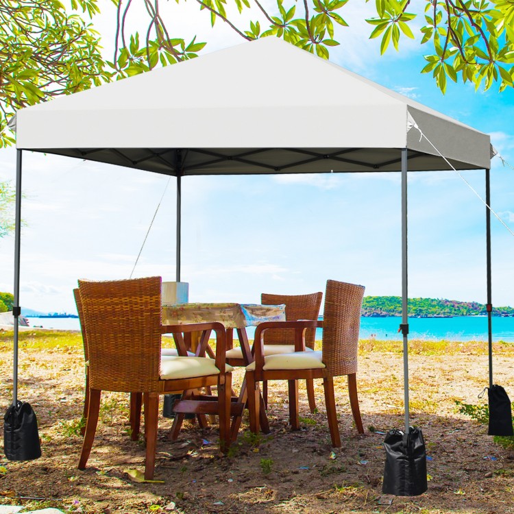 8’x8' outdoor pop-up canopy tent in white set up beside a table and chairs, providing ample shade for outdoor.