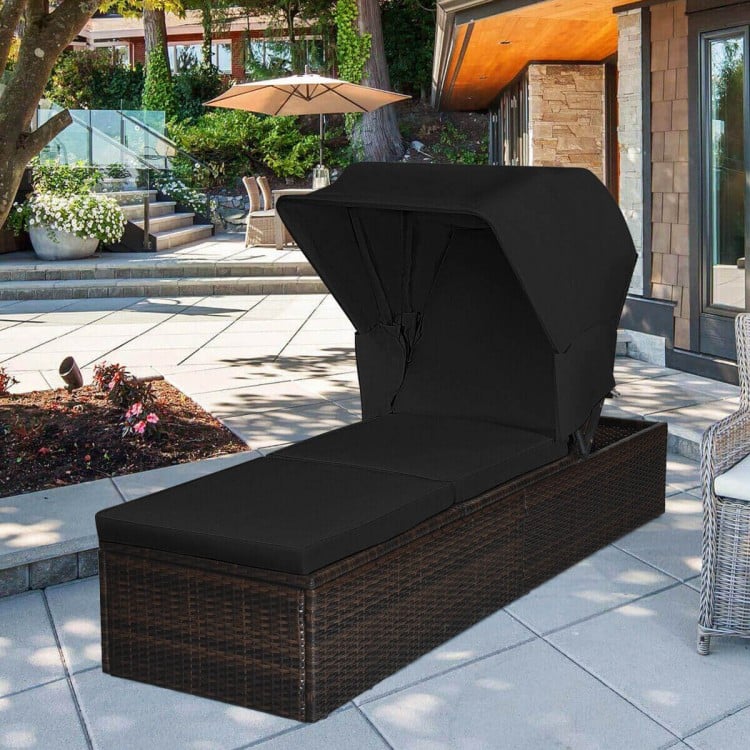 Adjustable cushioned chaise lounge chair with folding canopy in black, made of durable PE rattan for outdoor relaxation.