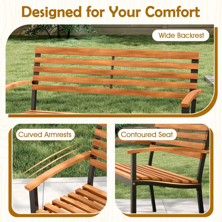 Close-up of the acacia wood outdoor bench showing the wide backrest, curved armrests, and contoured seat for comfort.