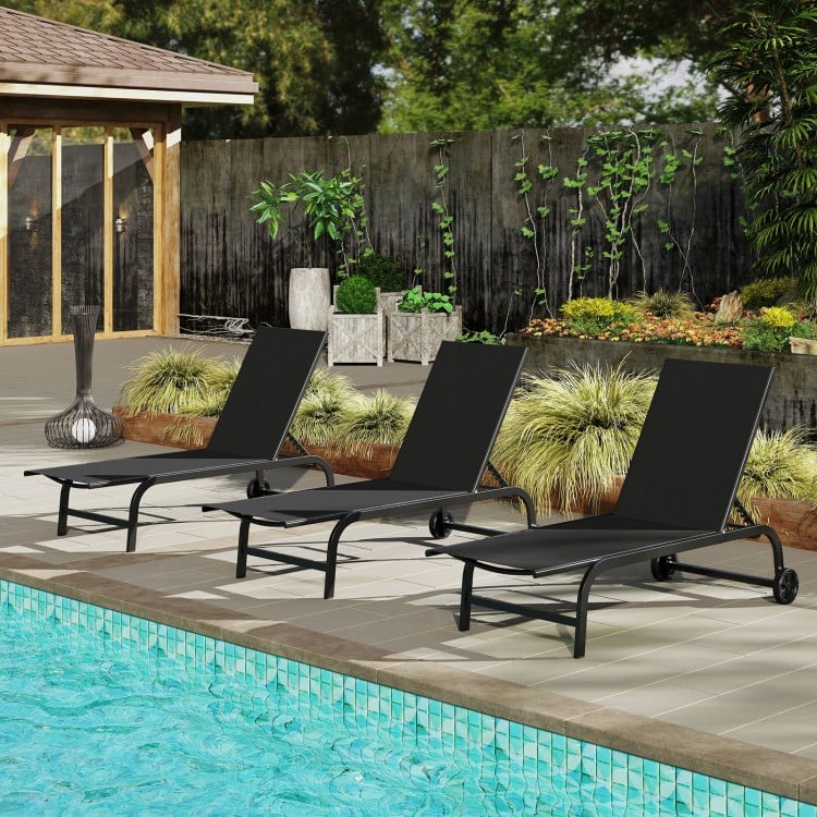 Black outdoor chaise lounge chairs with wheels and metal frame, arranged by the pool for relaxation.