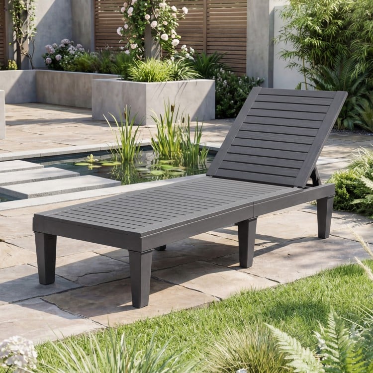 Grey outdoor chaise lounge chair with adjustable backrest, perfect for patio or poolside relaxation.