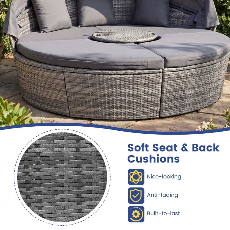 Round outdoor daybed with gray PE wicker, retractable canopy, and soft cushions for backyard relaxation.