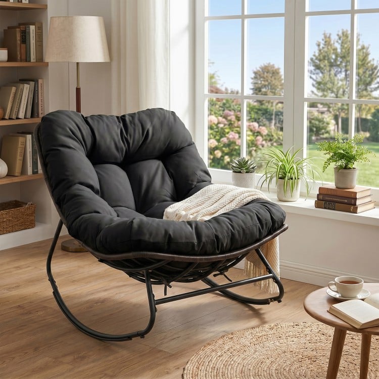 Black outdoor Papasan rocking chair with thick cushion, ergonomic design, and gentle rocking for comfortable relaxation.