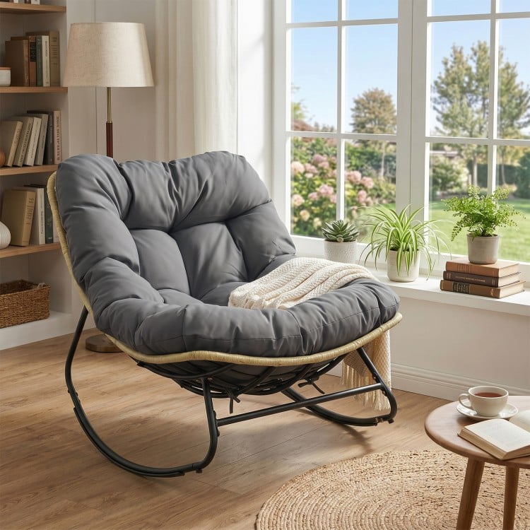 Gray outdoor Papasan rocking chair with thick cushioned seat, designed for comfort and relaxation in patio settings.