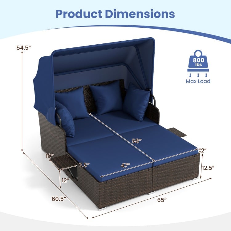Outdoor patio rattan daybed with retractable canopy, navy cushions, and side tables, ideal for backyard relaxation.