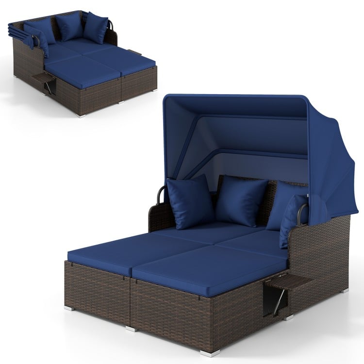 Outdoor patio rattan daybed with retractable navy canopy and side tables, ideal for backyard relaxation and sunshade.