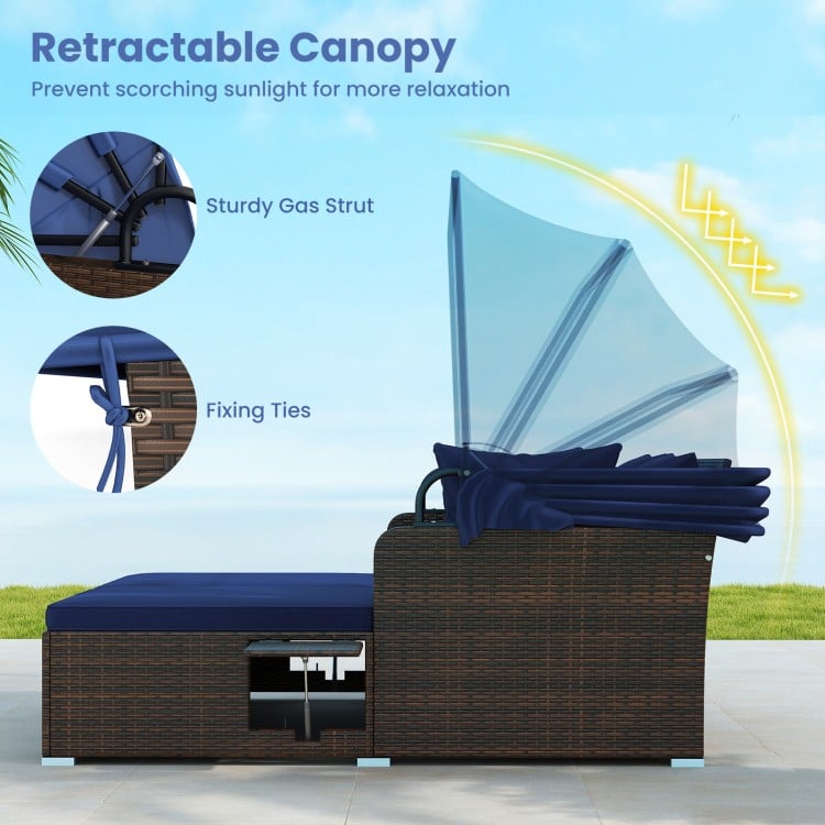 Side view of the outdoor patio rattan daybed with retractable canopy and navy cushions, ideal for backyard relaxation.