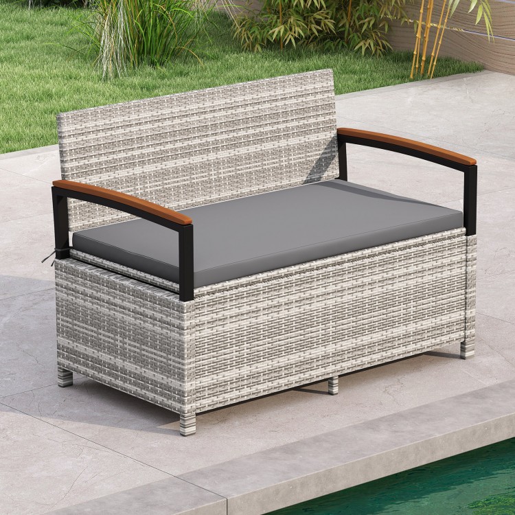 Outdoor storage bench with gray cushion, made of PE rattan and acacia wood armrests, perfect for patio or garden use.