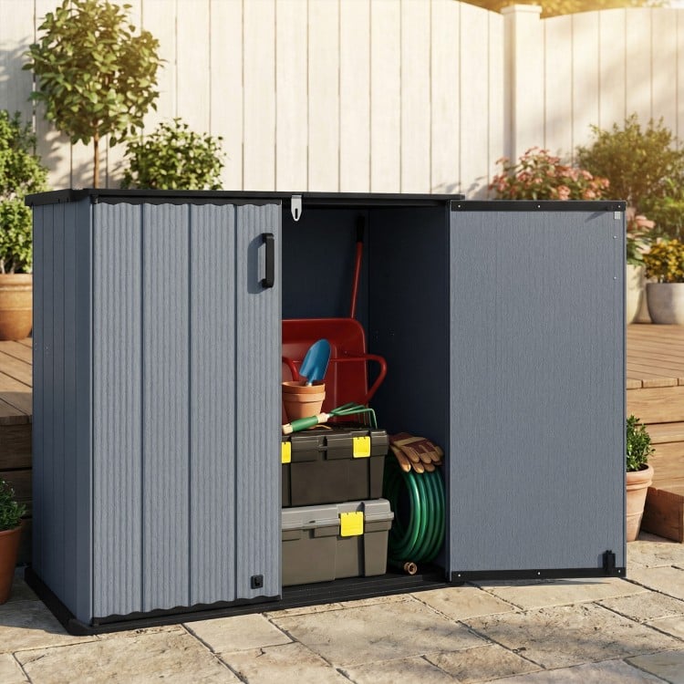 Outdoor storage shed in gray with lockable door, ideal for organizing gardening tools and equipment in various weather.
