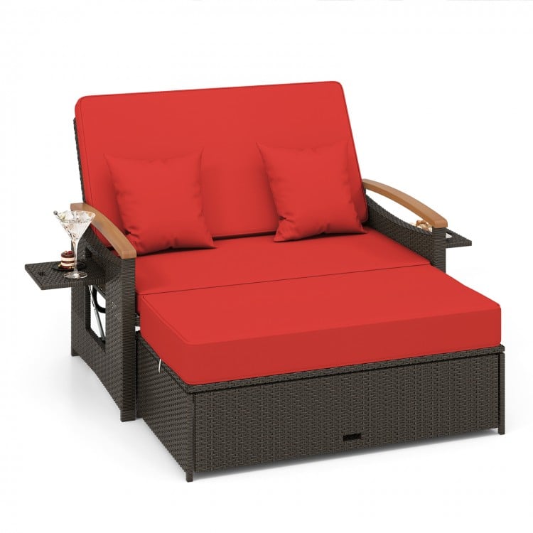 Red outdoor wicker daybed with adjustable backrest, storage ottoman, and comfortable cushions for patio relaxation.