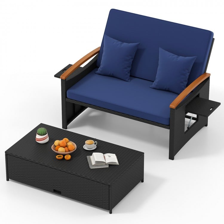 Dark blue outdoor wicker loveseat with cushions, folding panels, and storage ottoman, perfect for patio relaxation.