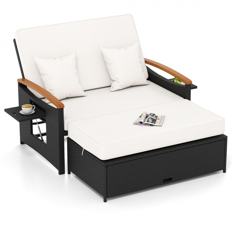 Outdoor wicker daybed with white cushions, adjustable backrest, and storage ottoman for versatile patio relaxation.