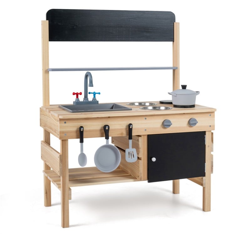 Wooden outdoor mud kitchen for kids featuring sink, stovetop, storage cabinet, and blackboards for imaginative play.