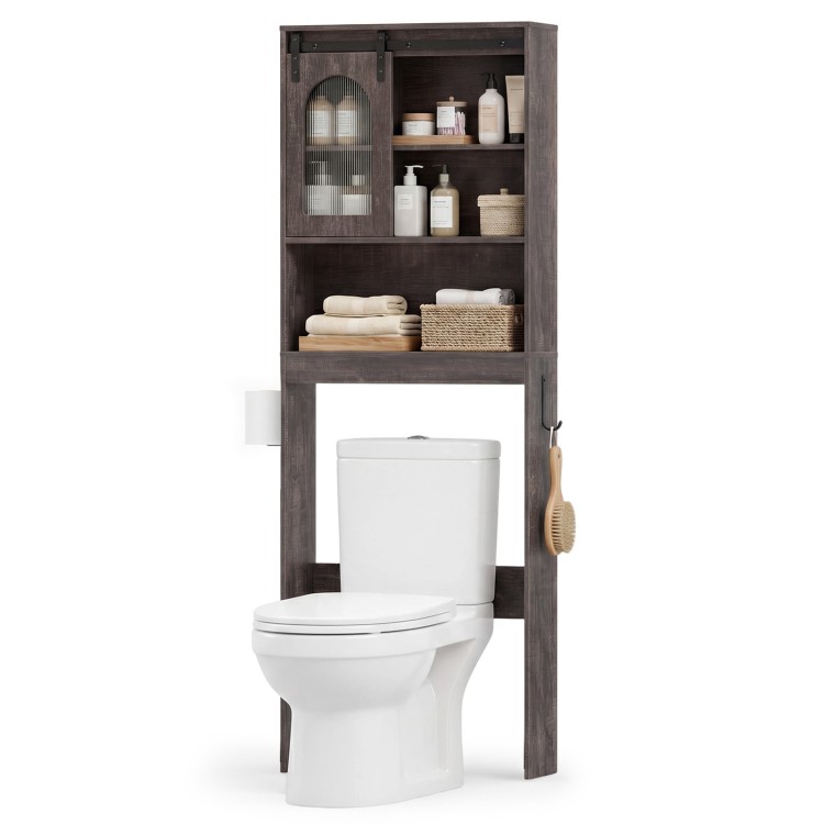 Over toilet storage cabinet with sliding barn door, open shelves, and hooks for towels and toilet paper in rustic oak.
