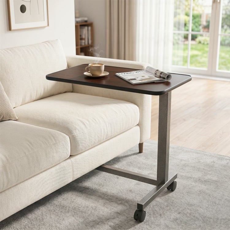 Overbed table with walnut finish, lockable wheels, and sturdy H-shaped base, ideal for home or hospital use.