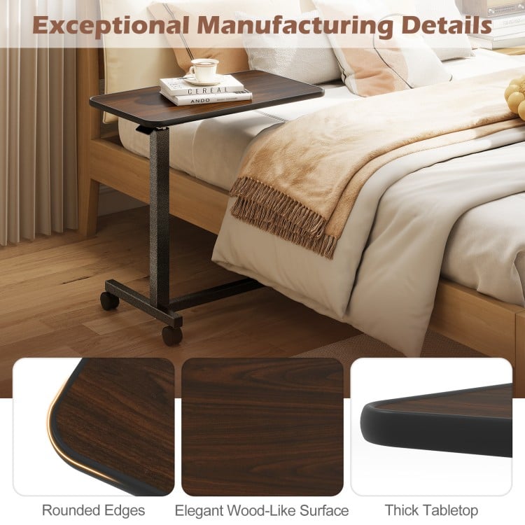 Overbed table with a walnut wood-like surface, lockable rolling wheels, and a sturdy H-shaped base for versatile use.