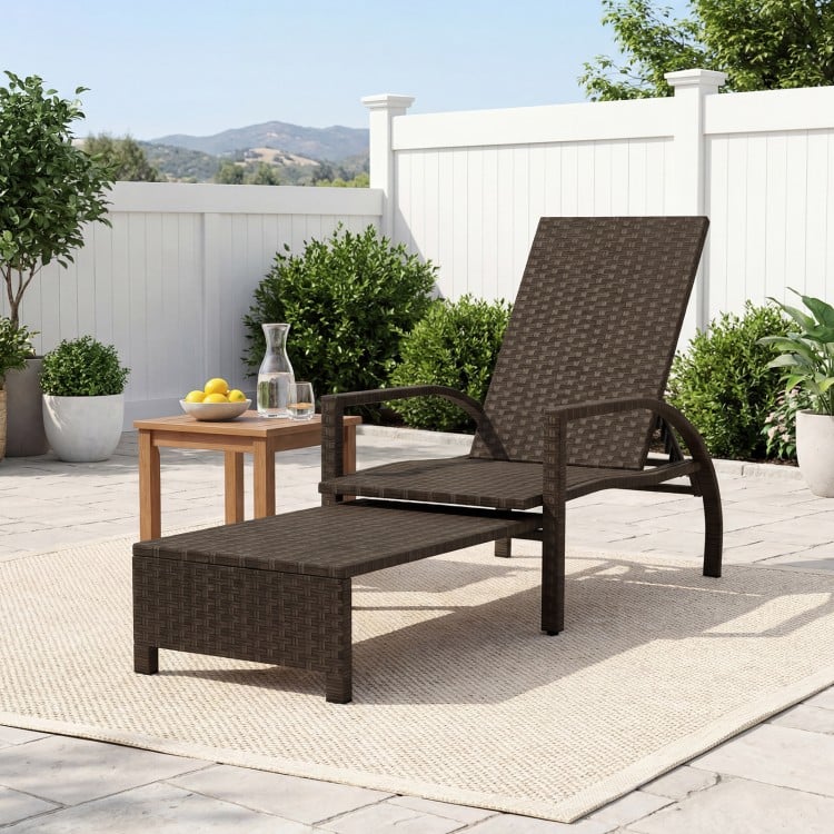 Patio chaise lounge with retractable ottoman, ergonomic design, durable rattan, perfect for backyard relaxation.