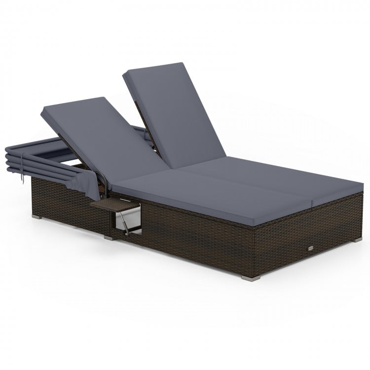 Patio double chaise lounge with gray cushions, adjustable backrests, and folding side trays for backyard relaxation.