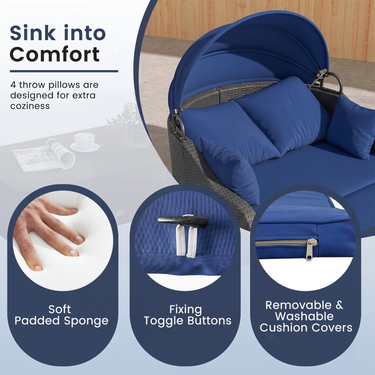 Patio PE rattan daybed features a retractable canopy, soft navy cushions, and four throw pillows for ultimate comfort.