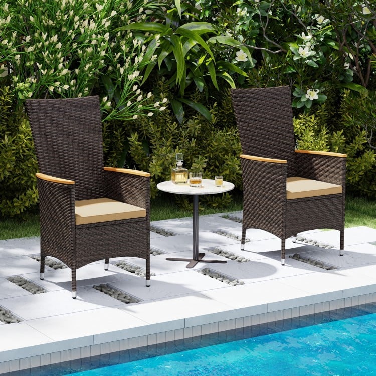 High-back patio rattan chairs with beige cushions, set by the poolside for outdoor dining and relaxation.