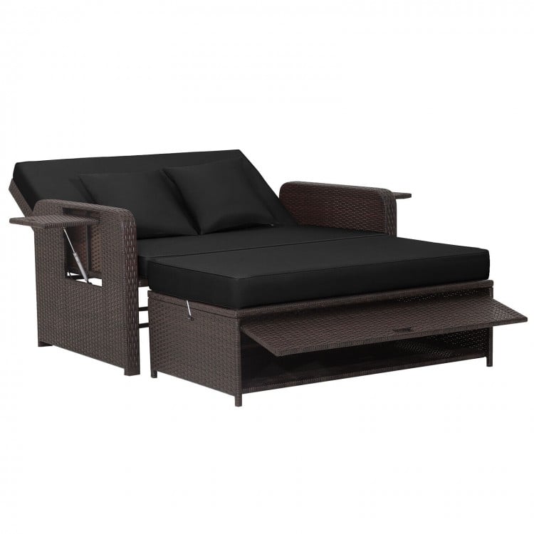 Patio rattan daybed in black with adjustable backrest, soft cushions, and retractable side trays for outdoor relaxation.