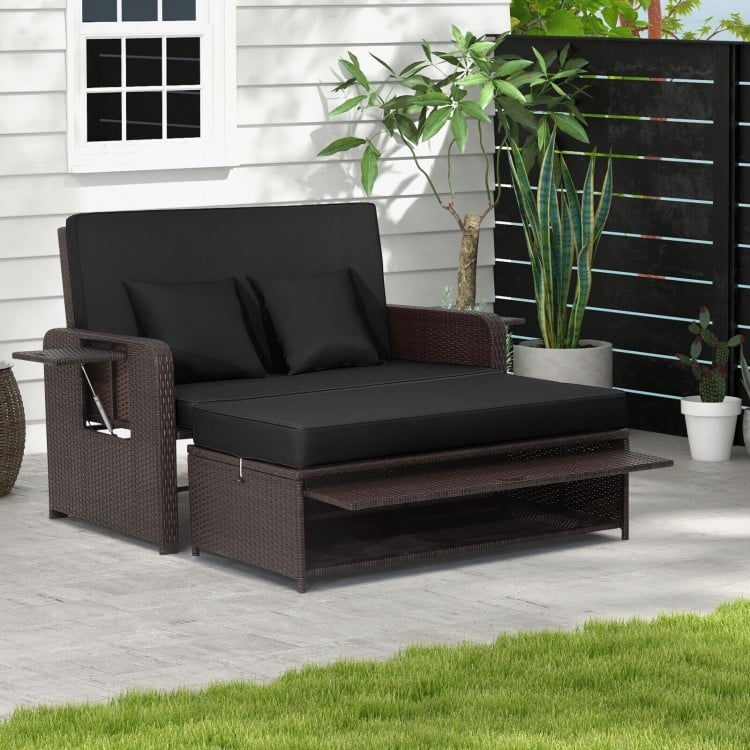 Black patio rattan daybed featuring an ergonomic design, soft cushions, and a side tray, ideal for garden lounging.