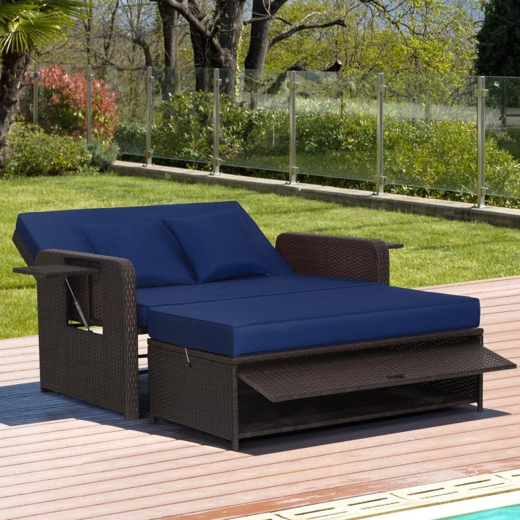 Patio rattan daybed in navy with adjustable backrest and retractable side trays, perfect for backyard relaxation.