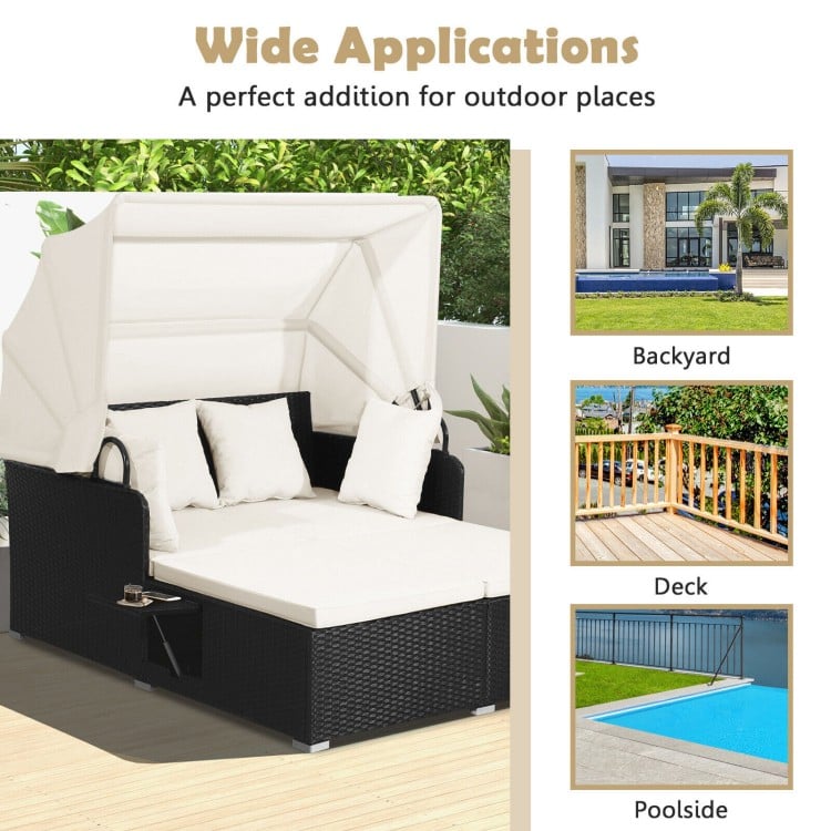 Patio rattan daybed with retractable canopy and soft cushions, perfect for backyard or poolside relaxation.